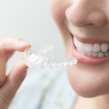 woman with bright smile applying her Invisalign