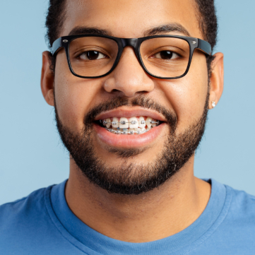 adult man with glasses and braces smiling